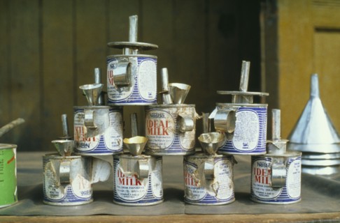GHANA, Tarkwa, Nestle evaporated milk cans made into oil lamps.