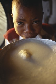 TANZANIA			, "				", Singida, Young boy next to bowl of breakfast at the Kititimo Centre School for