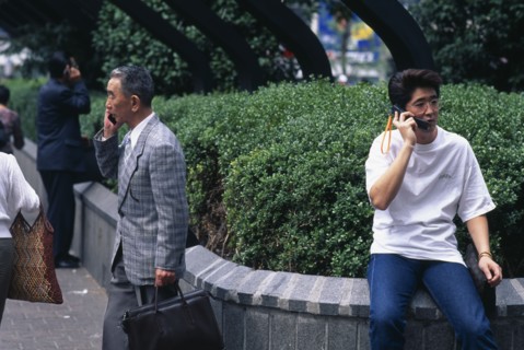 JAPAN, Shibuya, Tokyo, Three men ranging in age talking on mobile phones.