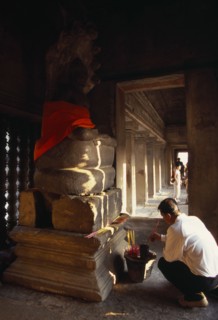CAMBODIA, Siem Reap Province, Angkor Wat, Interior of shrine on the upper level with visitor