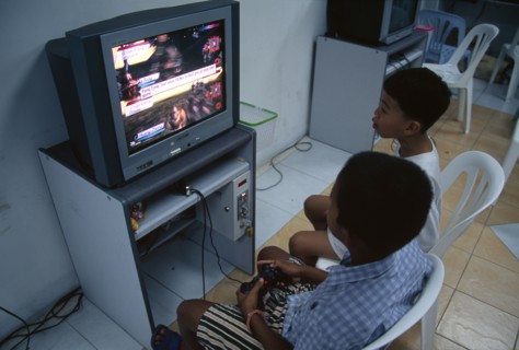 THAILAND, South, Bangkok, Two young boys playing a computer game in a shopping mall on Thanon Silom