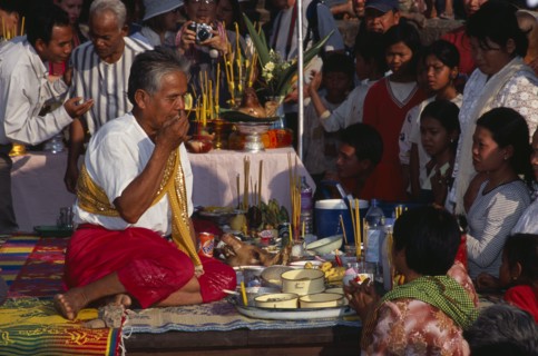 CAMBODIA, Siem Reap, Angkor Wat, Shaman at ceremony smelling the offerings of food brought by the