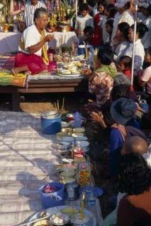 CAMBODIA, Siem Reap, Angkor Wat, Shaman at ceremony smelling the offerings of food brought by the