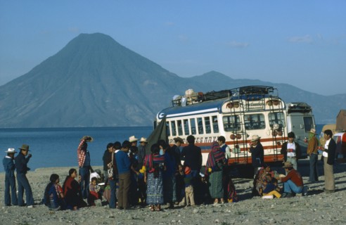 MEXICO, Transport, A group of passengers gathered around a bus with mountain scenery behind.