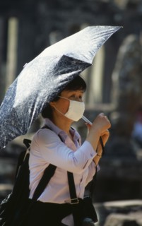 CAMBODIA, Siem Reap Province, Angkor Thom, Japanese tourist at Bayon Temple wearing a face mask and