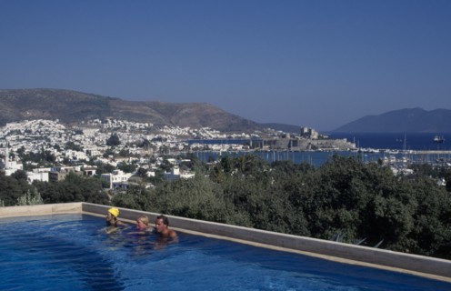 TURKEY, Aegean Region, Mugla, Bodrum.  People in swimming pool of Antik Theatre Hotel in foreground