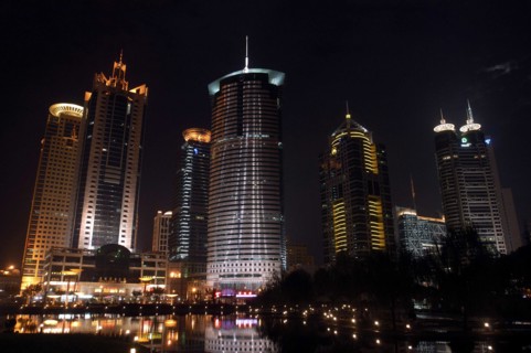 CHINA, Shanghai, Waterfront city skyline with skyscrapers illuminated at night