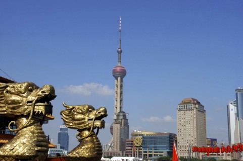 CHINA, Shanghai, City skyline and Television Tower with golden dragon head statues in the