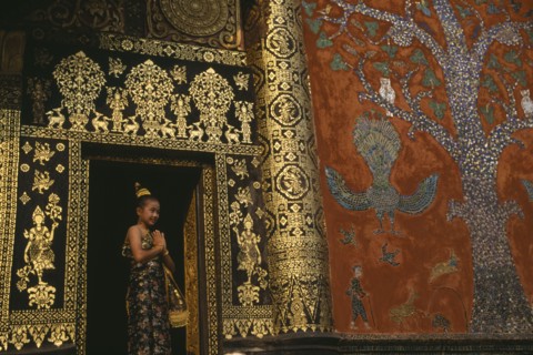 LAOS, Louangphrabang , Young girl dressed for Lao New Year at Wat Xieng Thong with highly decorated