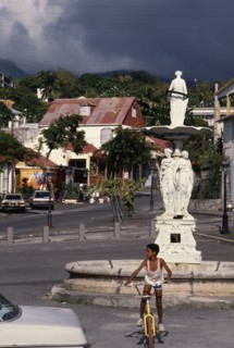 WEST INDIES, Guadeloupe, Basseterre, Large white statue in middle of street surrounded by houses