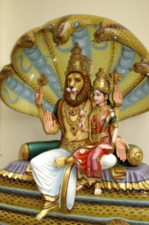 SINGAPORE, , Colurful statue of a lion headed God with four arms and a female figure sitting on his
