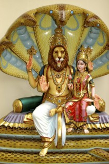 SINGAPORE, , Colurful statue of a lion headed God with four arms and a female figure sitting on his