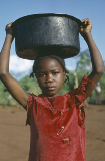 CONGO, Tribal Peoples, Young girl carrying water vessel on her head.