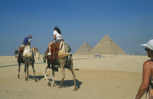 EGYPT, Cairo, Tourists on camels visiting the pyramids