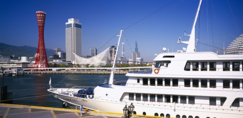 JAPAN, Honshu, Kobe, View over the port area with moored passenger ferry in the foreground and the