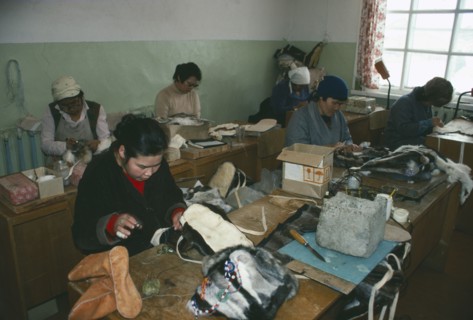 RUSSIA, Siberia, Kamchatka, Lesnoe.  Workers in factory making boots and hats from reindeer skin.