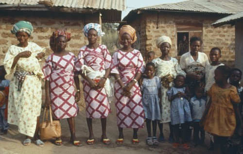 NIGERIA, Marriage, "Polygamy.  Wives of the same man, framed in window behind, wearing dresses made
