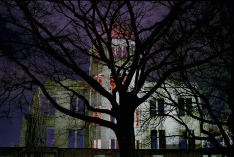 JAPAN, Honshu, Hiroshima, View of the A Bomb Dome illuminated at night seen through silhouetted