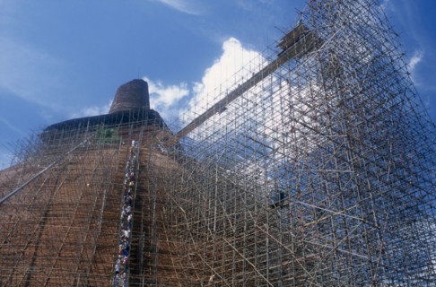 20045345 SRI LANKA  Anuradhapura Jetavanarama dagoba.  Huge brick dome undergoing reconstruction.  Line of workers on network of scaffolding covering exterior.