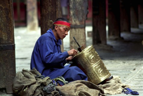 CHINA, Tibet, Lhasa, Man repairing prayer wheel as Penance at the Jokhang Temple