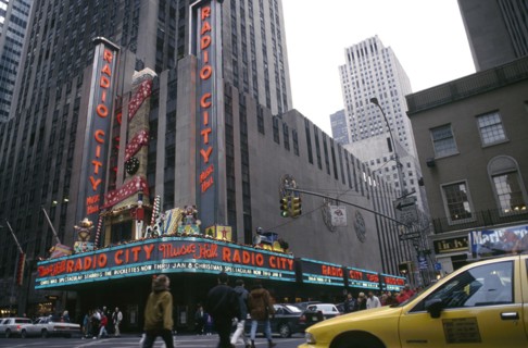 USA, New York, New York, City street scene with Radio City advertising Christmas lineup and yellow