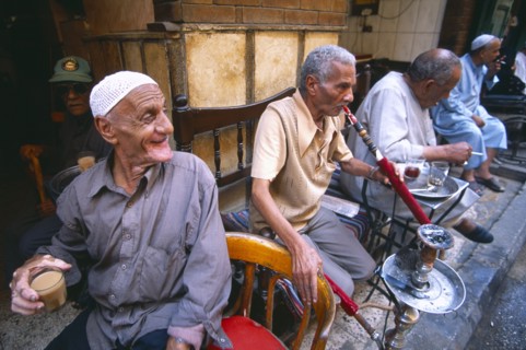EGYPT, Cairo , Group of men smoking sheesha water pipes and drinking tea in an ahwa or coffee house
