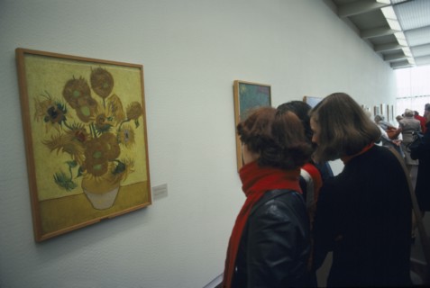 HOLLAND, North, Amsterdam, Visitors inside the Van Gogh Museum looking at painting of Sunflowers.