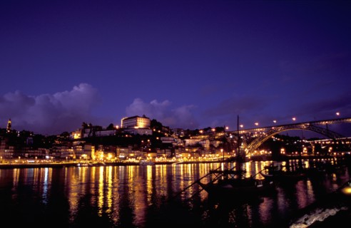 PORTUGAL, Porto, Oporto, View over silhouetted boats moored in the port toward the city illuminated