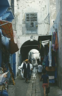 TUNISIA, Tunis, Market scene.  Men and children walking through narrow cobbled street lined with