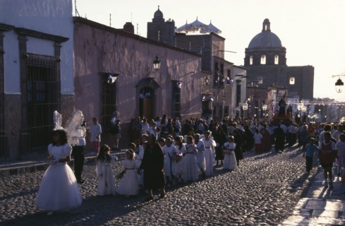 MEXICO, San Miguel de Allende, Easter Procession down cobbled street with children dressed in white
