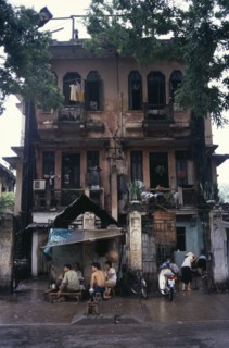 VIETNAM, North, Hanoi, Decayed French colonial style residential buildings with people sheltering