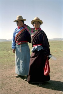 CHINA, Gansu, Xiahe, Full length portrait of two sisters travelling on foot to local festival