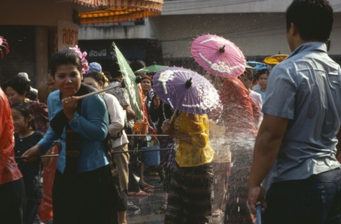 THAILAND, North, Chiang Mai , Girls with umbrellas being sprayed with water on the street during