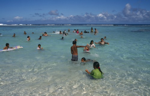 PACIFIC ISLANDS, Polynesia, Cook Islands, Atiu.  Girls swimming in the harbour.
