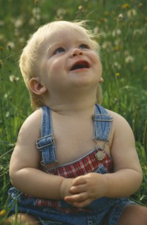 CHILDREN, Babies, One year old baby boy sitting in long grass and looking upwards