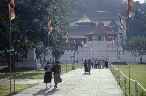 SRI LANKA, Kandy, People walking down flag lined walkway toward the Temple of the Tooth