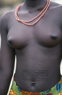 SUDAN, Scarification, Symmetrical pattern of raised scars decorate the abdomen of a young Dinka
