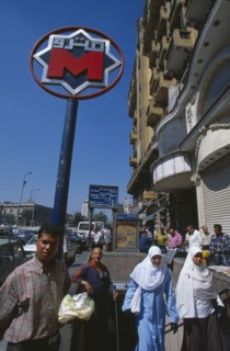 EGYPT, Cairo , Nasser metro station.  Men and women at subway entrance with sign above.