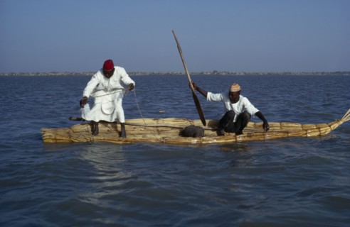 CHAD, Lake Chad, Two Buduma tribesmen fishing in a reed boat on the lake