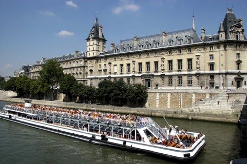 FRANCE, Ile de France, Paris, Open top tourist boat travelling down the River Seine