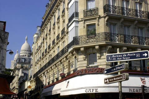 FRANCE, Ile de France, Paris, Corner cafe  and street signs with the domes of the Sacre Coeur in