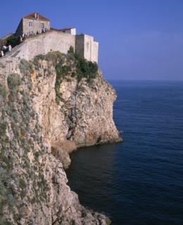 CROATIA, Dalmatia, Dubrovnik, Tourists climbing the city walls atop a rocky cliff overlooking the