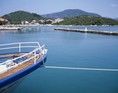 CROATIA, Dalmatia, Ston, Prow of a moored boat with coastline beyond