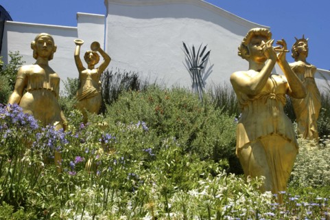 SOUTH AFRICA, Western Cape, Cape Town, Golden statues standing among flowers at a Winery