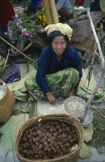 MYANMAR, Yaungshwe, Woman selling rice cakes at street market near Inle Lake.
