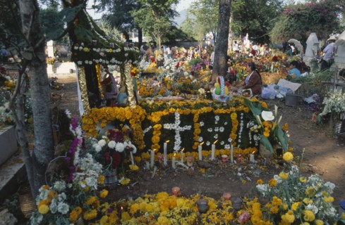 MEXICO, Michoacan State, Patzcuaro, Tomb in Tzurumutaro Cemetary decorated with flowers fruit and