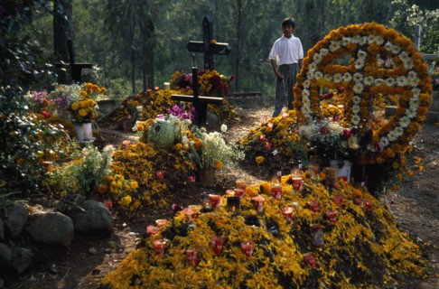 MEXICO, Michoacan State, Patzcuaro, Graves in Tzurumutaro Cemetary decorated with flowers fruit and
