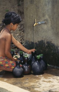 BANGLADESH, Water, Mrong girl fetching water from outside tap in small flasks.
