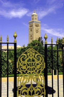 MOROCCO, Marrakech, View through black and gold wrought iron gate towards the minaret of Koutoubia