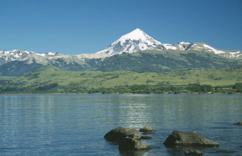 ARGENTINA, Neuquen, Lanin National Park, View over bolders of Huechulafquen Lake toward snow capped